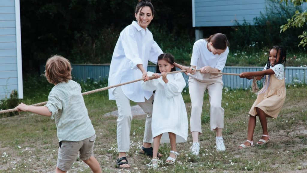 Family playing tug of war in backyard, showcasing teamwork and joy.