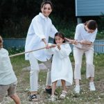 Family playing tug of war in backyard, showcasing teamwork and joy.